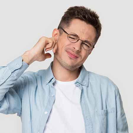 Man wondering about the earwax in his ear