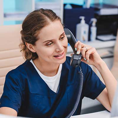 Woman on the phone checking on hearing aid insurance coverage